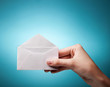 woman's hand holding opened envelope against blue background
