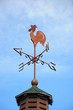 Wind cock weather vane direction on blue sky