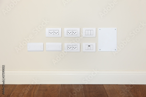 Photo: Power outlet and light switch on the wall Power outlet and light switch on the wall
