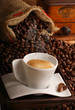 Caffè italiano in tazza bianca e chicchi tostati sullo sfondo Caffè italiano in tazza bianca e chicchi tostati sullo sfondo