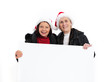 Zwei Seniorinnen mit Weihnachtsmannmützen und Tafel 01
