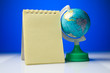 Notepad with globe on a blue-and-white background