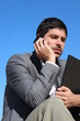 A businessman is talking on his smartphone outdoor
