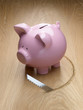 Saw cutting a hole around a piggy bank