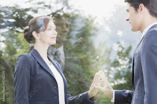 Photo: Business people looking at each other through glass Business people looking at each other through glass