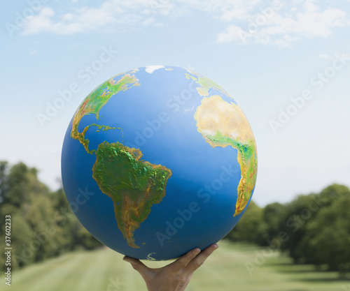 Photo: Hand holding large globe outdoors Hand holding large globe outdoors