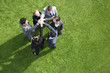 Business people standing in circle holding hands