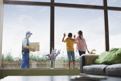 Photo: Children watching deliveryman arriving with package Children watching deliveryman arriving with package