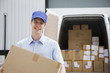 Deliveryman carrying box from van