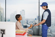 Foto: Businesswoman signing for package in office Businesswoman signing for package in office