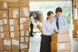Business people using laptop in warehouse
