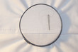 Embroidery hoop with running stitch and needle on cotton fabric