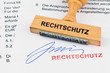 Holzstempel auf Dokument: Rechtschutz