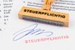 Holzstempel auf Dokument: Steuerpflichtig