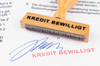 Holzstempel auf Dokument: Kredit bewilligt