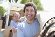 Men carrying carpet from moving van