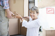 Couple unloading boxes from moving van