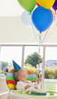 Baby with birthday cake holding balloons