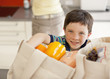 Boy unloading groceries from reusable bag