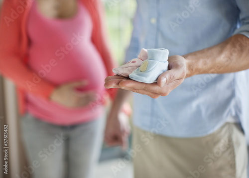Photo: Close up of man holding baby booties Close up of man holding baby booties