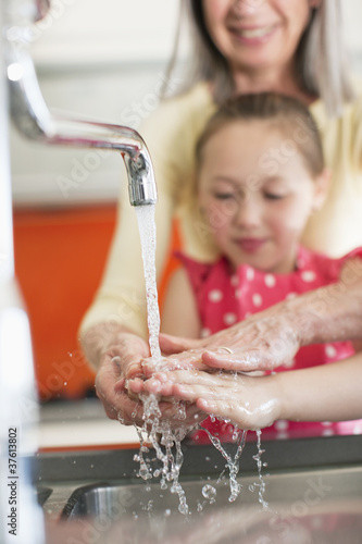 Photo: Grandmother helping granddaughter to wash her hands Grandmother helping granddaughter to wash her hands