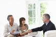 Couple shaking hands with financial advisor
