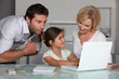 Parents and daughter with laptop computer