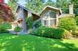 Beautiful green front garden with brown house.