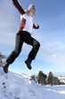 Woman jumping onto a pile of snow