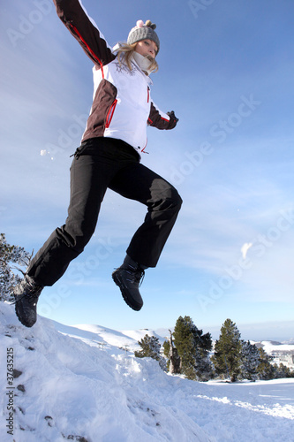 Photo: Woman jumping onto a pile of snow Woman jumping onto a pile of snow