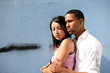 Teens embracing in front of a wall
