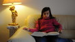 Mädchen liest ein Buch auf dem Sofa