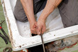 Plumber cleaning drain in bathroom with cable Plumber cleaning drain in bathroom with cable