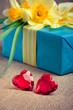 Two red glass hearts with a gift box and flowers