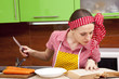 Photo: Woman in the kitchen with knife recipe book Woman in the kitchen with knife recipe book