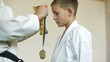 boy receive karate trophy and medal for the victory
