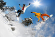 Snowboarders  jumping against blue sky