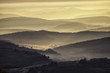 valley in a beautiful early morning with fog and hills