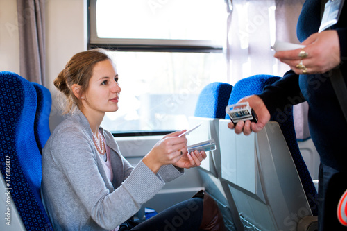 Photo: woman having her ticket checked by the conductor woman having her ticket checked by the conductor