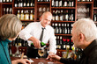 Wine bar senior couple barman pour glass Wine bar senior couple barman pour glass