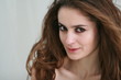 Portrait of young woman with curly hair against white background