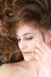 Young beautiful woman with curly hair on black background