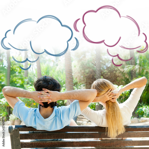 Photo: Smiling beautiful couple sitting on a banch at summer park and d Smiling beautiful couple sitting on a banch at summer park and d