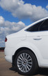 white modern car against the blue sky with clouds white modern car against the blue sky with clouds