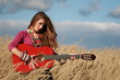 girl playing guitar in corn field