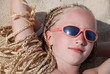 The girl with the African plaits lies on sand. A portrait. Egypt
