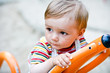 Young toddler   on a swing in the playground.
