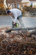 Man Cuts Tree Limbs with a Chainsaw