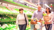Family of four in supermarket, vegetable section