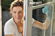 Junge Frau putzt Fenster
